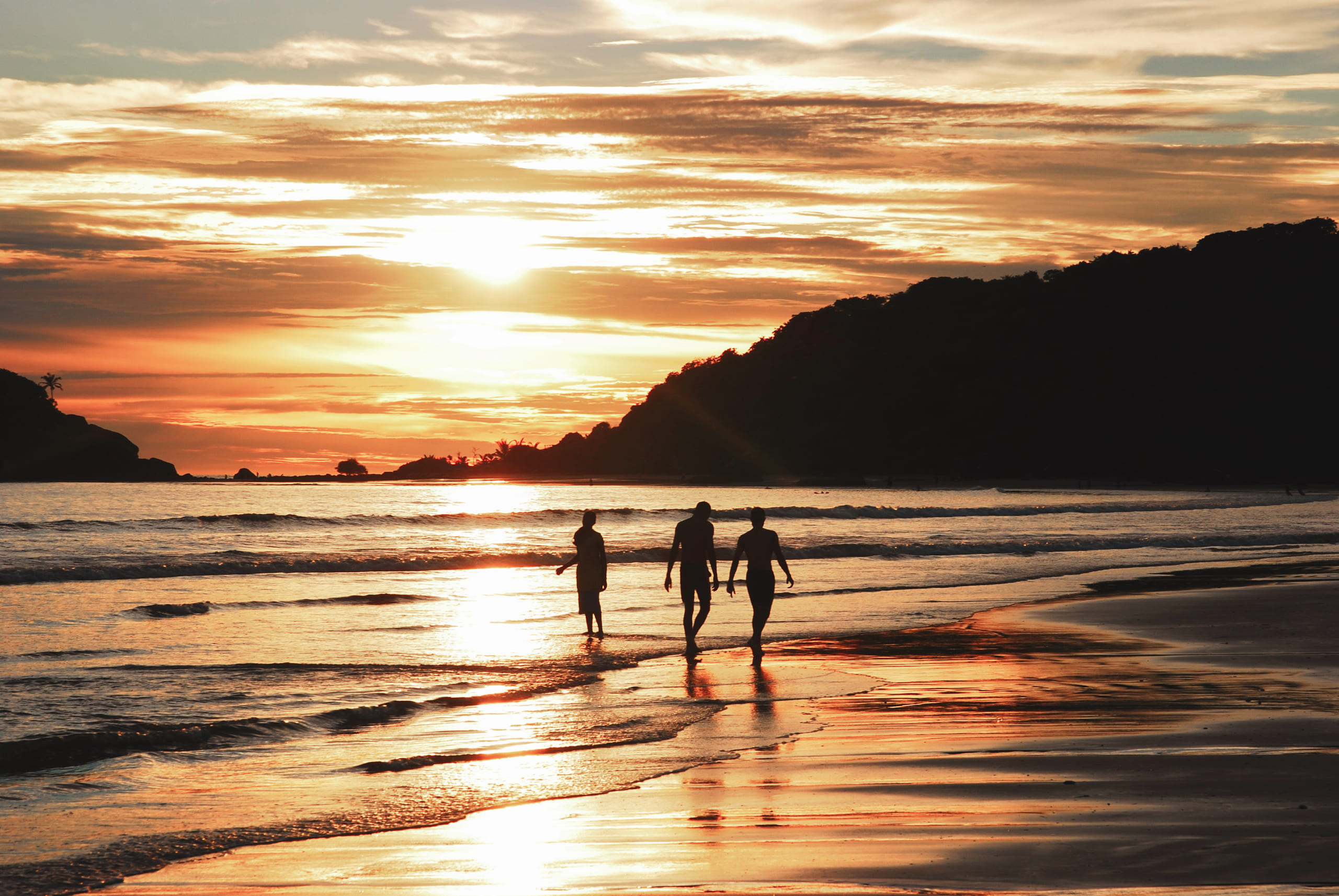 Friends,Walking,On,The,Beach,At,Sunset
