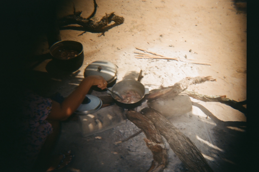 Ismael, 14, takes a picture of his mother, Hermelinda, 38, cooking in the community
