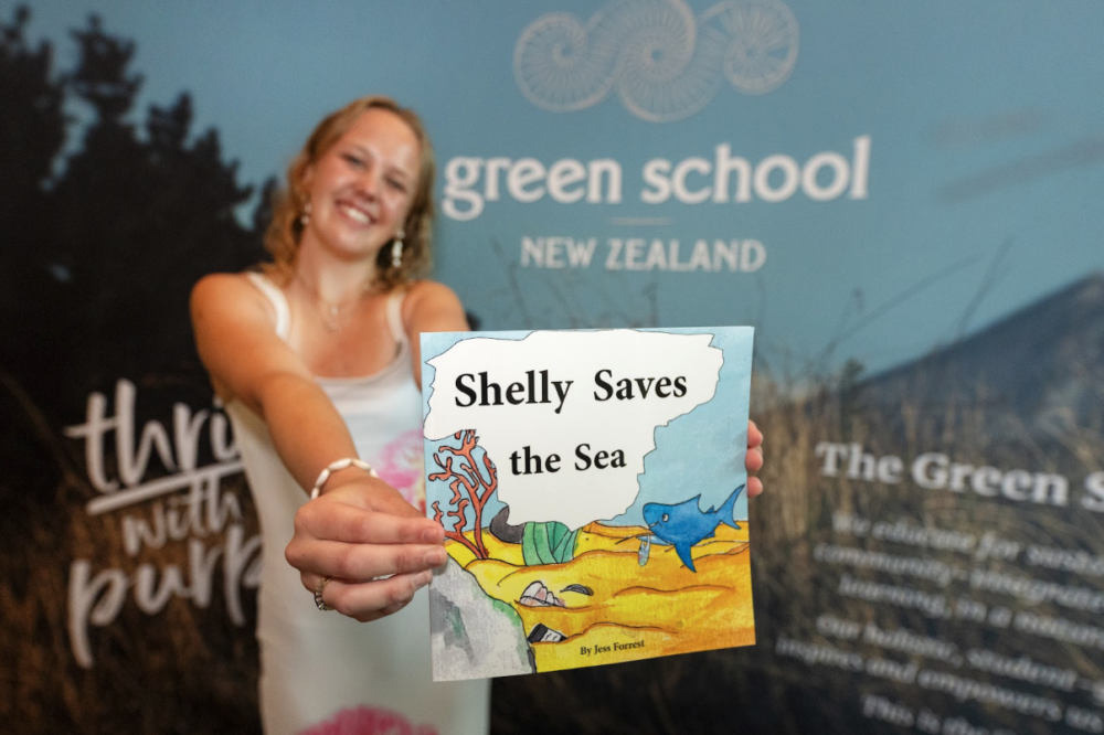 絵本と共に映る卒業生Jess|Image via Green School NZ