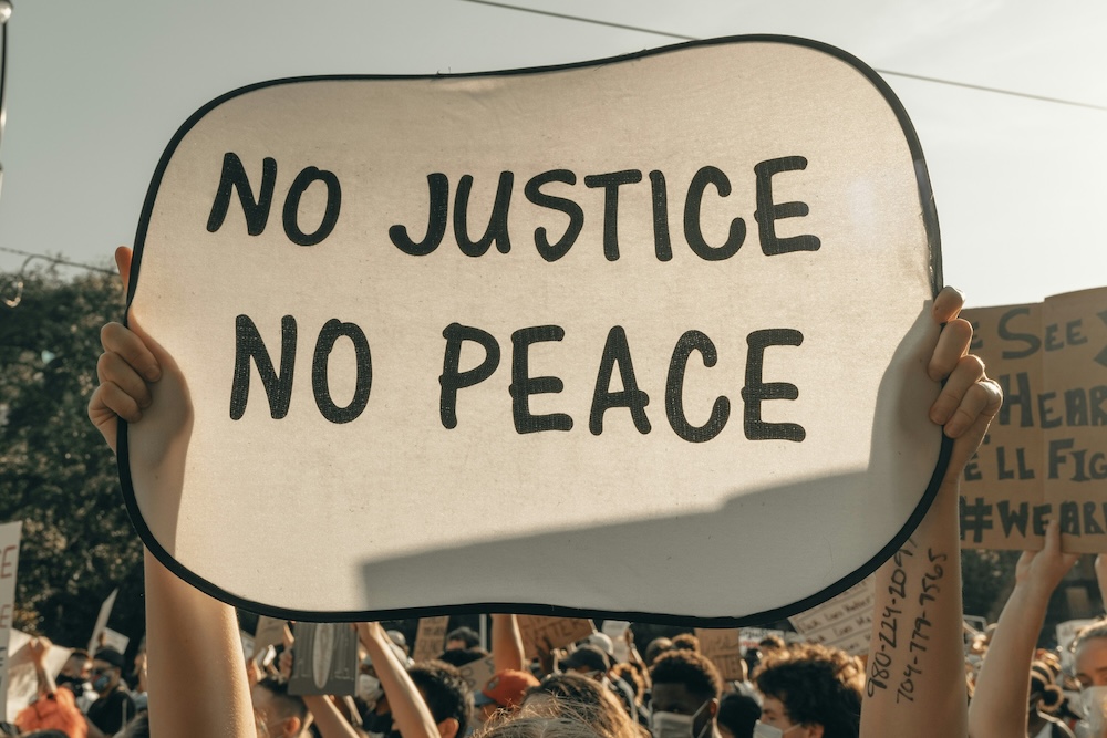 デモ中、No justice, no peaceのサインを掲げている様子
