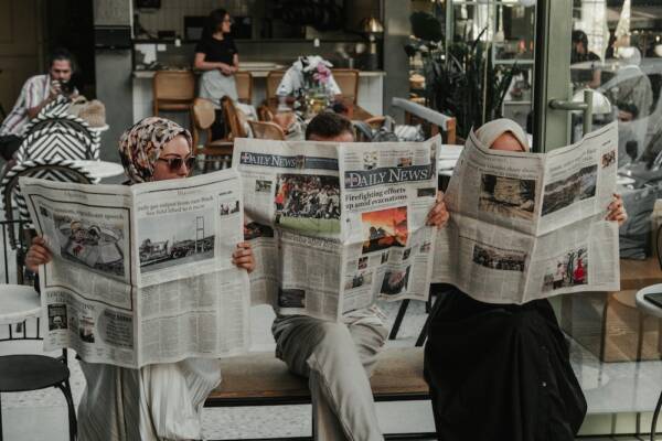 新聞を読む3人