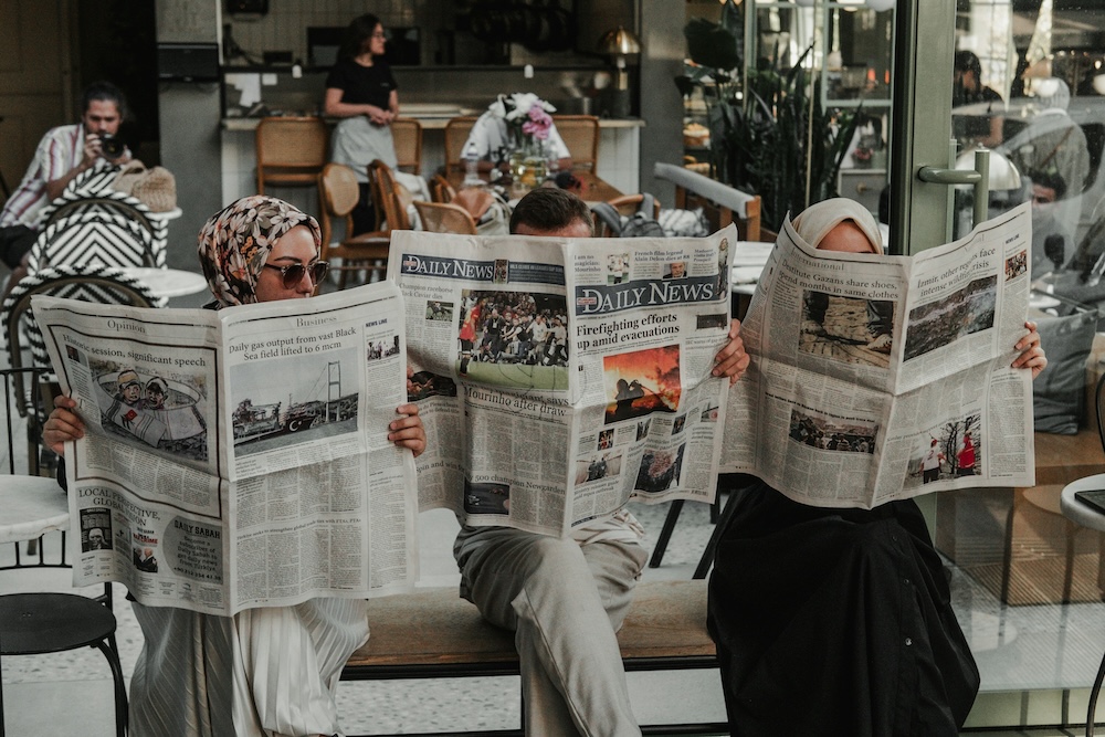 新聞を読む3人