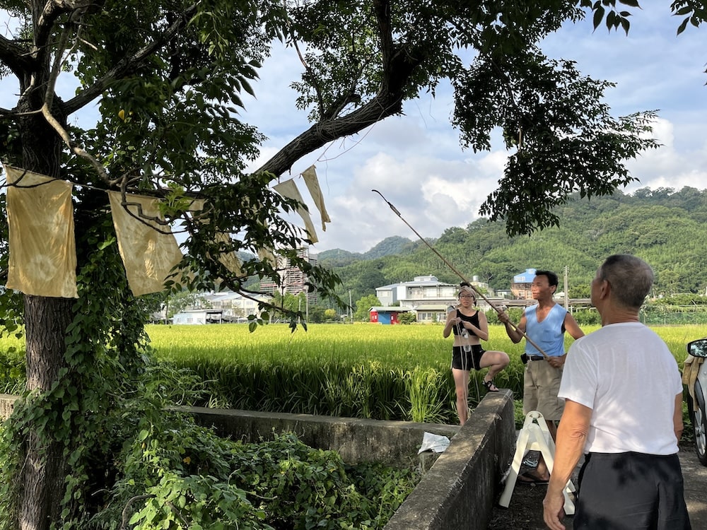 地元の人と一緒に、川の近くで展示準備をする様子